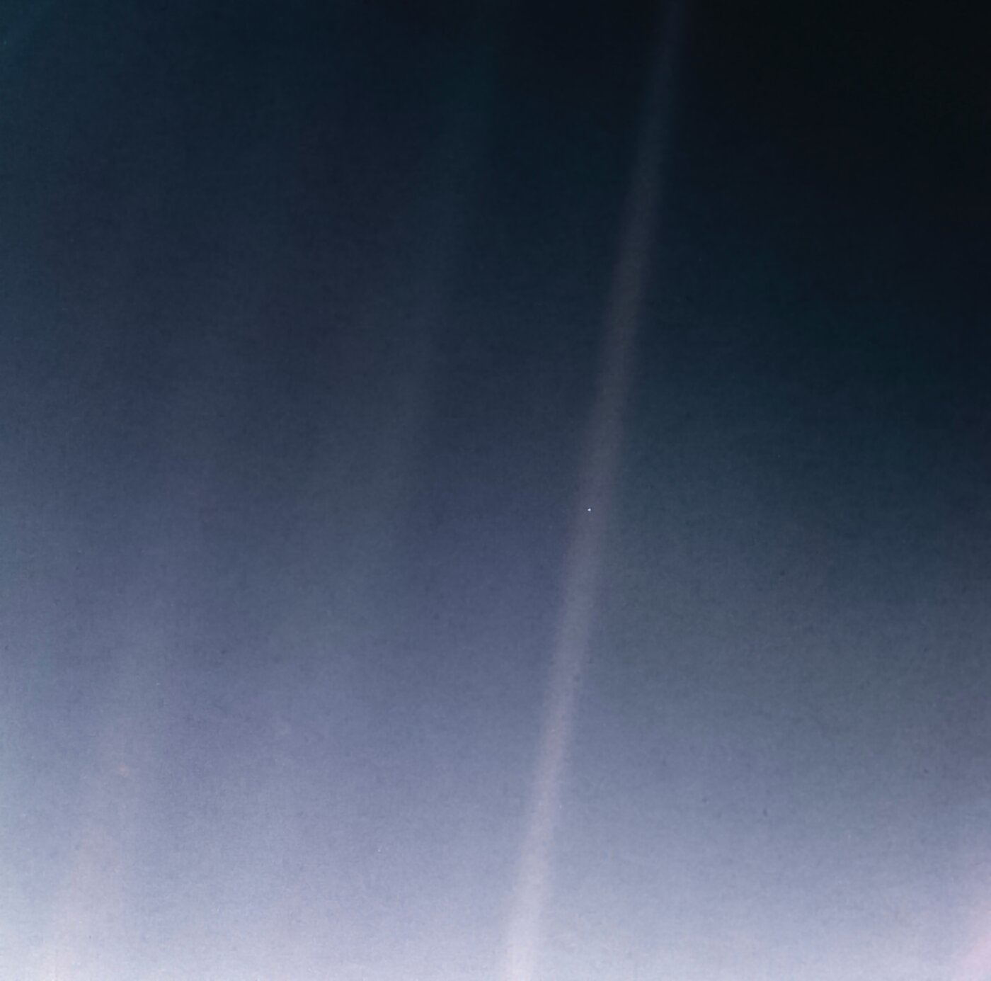 Pale Blue Dot — a Terra é o diminuto ponto azul-claro suspenso na faixa de luz solar à direita do centro, fotografada pela Voyager 1 a cerca de 6 bilhões de quilômetros de distância, em 14 de fevereiro de 1990, a pedido de Carl Sagan (versão reprocessada pela NASA em 2020). (NASA/JPL-Caltech)